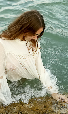 Danniela licks her lips, sheer fabric last shield as the waves catch her back in Serbia